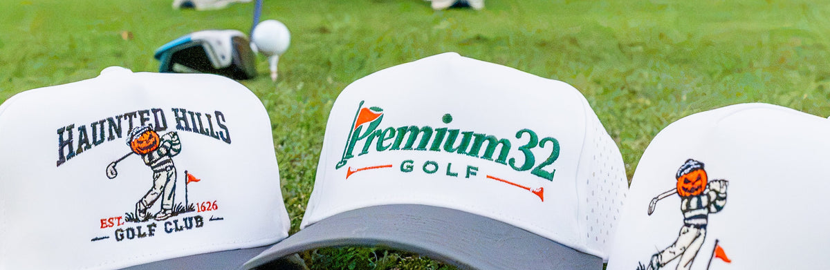 Halloween Golf Hat for Men.Haunted Hills Golf Club Hat. Three custom golf-themed trucker hats are lined up on a green grassy golf course, with a golfer in the background holding a club. The hats feature white mesh back panels, dark gray curved brims, and various golf club logos printed on the front. Premium32 Golf Hat. Halloween Golf Gift idea.